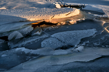 blocks of ice on the snow under the evening sun