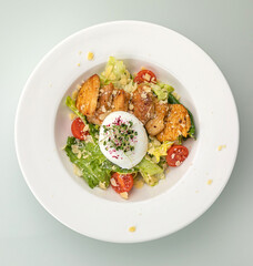 Caesar salad on a white plate and a white background
