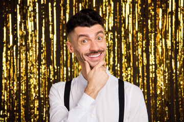 Photo of young cheerful man happy positive toothy smile hand touch chin think dream isolated over glitter color background