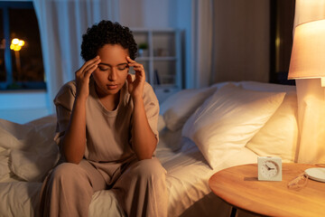 stressed african woman lying in bed at night