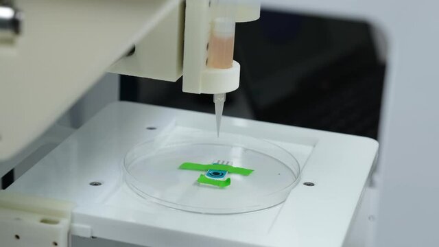 3D bioprinter printing a biomaterial onto an electrode. 4k video.