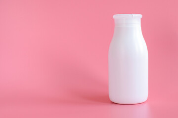 White plastic bottle for packaging, mockup, template on a pink background. Copy space for text.