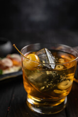 Cocktail with ice and cherry on a dark table. Snacks for a cocktail
