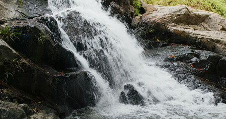 Waterfall flowing from the cliff in forest