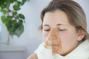 portrait of a young woman inhaling medicines for bronchitis and asthma at home