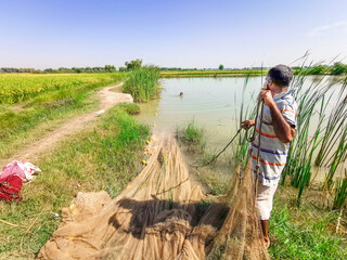 fisher man is catching fish by his net