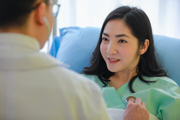 Fototapeta premium Doctor using stethoscope on chest of female patient during healing process.