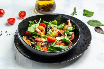Fresh salad bowl with smoked shrimps, cherry tomatoes, cucumber and mixed leaves, Healthy food. Clean eating. top view