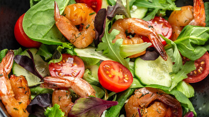 Shrimps salad, cherry tomatoes, cucumber and mixed leaves. Healthy food. Clean eating. Food recipe background. Close up