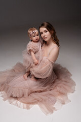 Woman in light clothes have fun with cute child baby girl 1 years old. Mommy little kid daughter...