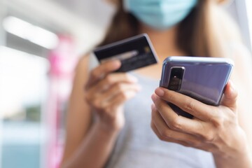 Close up image.A woman using smart phone for shopping online with credit card at coffee cafe.Online payment concept.