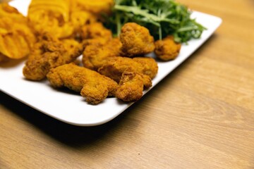 Chicken nuggets with salad on table closeup