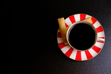 Coffee in a cup, cookies and black background