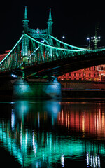 Fototapeta premium Budapest at night, Freedom Bridge on the Danube River, reflection of night lights on the water