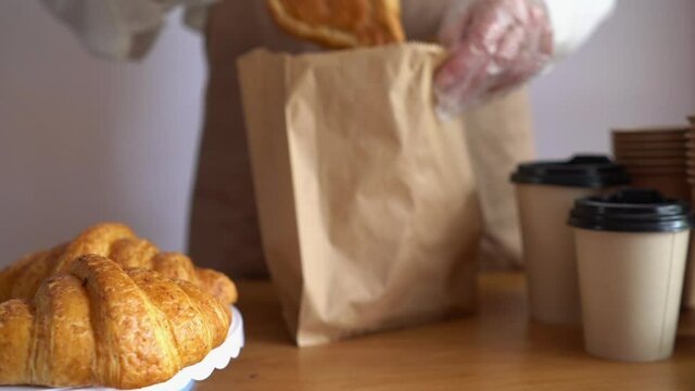 Waitress packs croissants into a paper bag