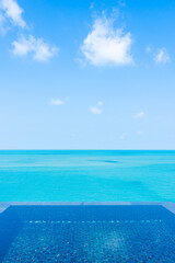 Fototapeta na wymiar Beautiful private infinity outdoor swimming pool with sea ocean white cloud and blue sky view