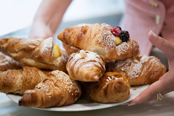 Freshly baked croissants on a plate with different fillings.