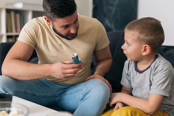 father explaining to his son how to use asthma pump