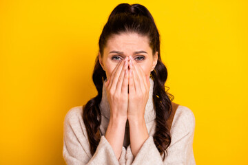 Close-up portrait of attractive worried nervous girl closing face crying suffering isolated over bright yellow color background