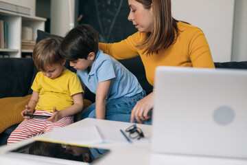 mother working from home. children are playing in background