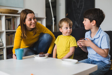 children eating chocolate muffins at home