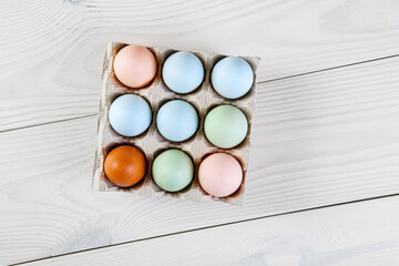 Fresh chicken organic eggs different colors in paper tray. Natural green, blue, pink and brown eggs.