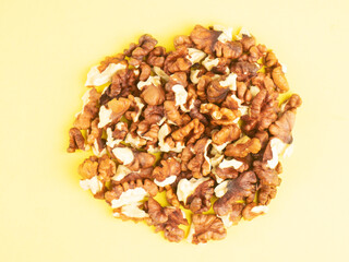 Handful of shelled walnuts on yellow