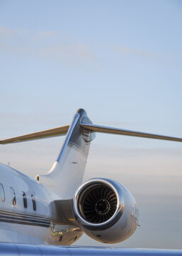 Business travel concept. Jet engine on parked luxury private jet. Rear detail with engine, tail-plane and windows of business-jet aircraft. Space for text.
