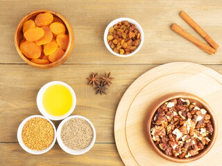 Raisins, walnuts, honey, dried apricot, cumin, fenugreek, star anise, cinnamon on brown wooden...