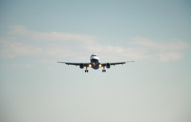 Commercial jet plane in the blue sky. Business trip on the airplane. Passenger aircraft is landing. Travel by air transport. Space for text.
