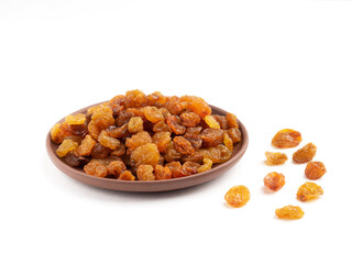 Raisins in clay plate on white