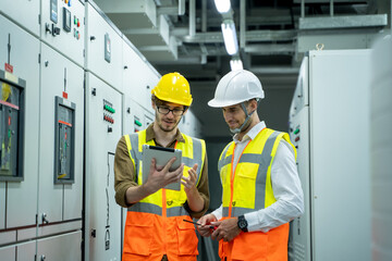 Technical worker with engineer working and checking in control room power plant at industry factory.