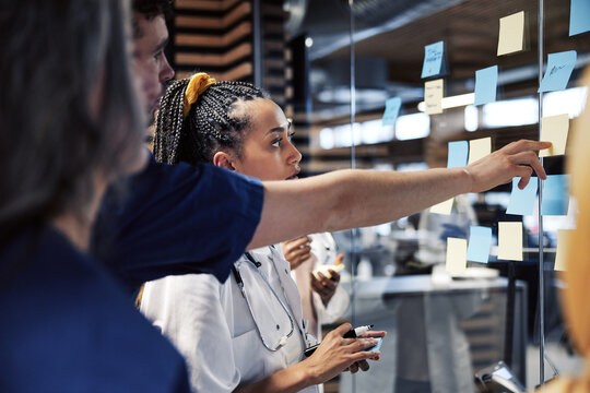 Diverse group of doctors brainstorming together with sticky notes