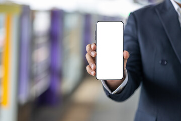 Close up male hand using smartphone and travel by sky train in train station.