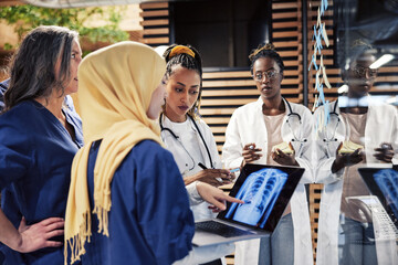 Doctors discussing a patient's x-ray on a laptop