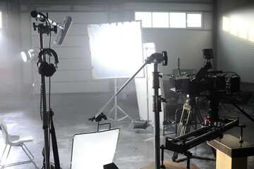 Profesional video studio.Behind-the-scenes of a video shooting.Behind the shooting production silhouette of camera and equipment in studio.Selective focus.