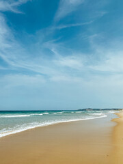 Tropical vacation concept. Soft long waves on the tropical shore of a long empty sea beach. Caribbean coast