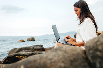 Freelance concept. A freelancer girl with a laptop on her lap works out of the office