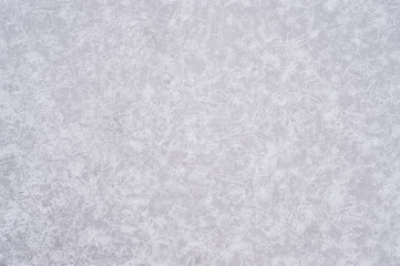 Abstract gray three-dimensional natural background of frozen glass in a pattern of cracks, air bubbles and drops.