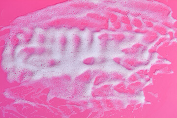 Foam bubbles and brick of soap on pink background. Cleaning service