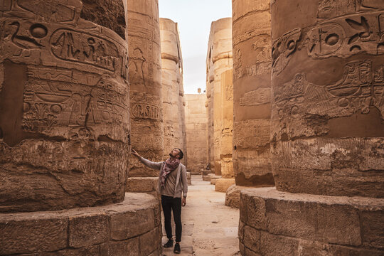 Young man gazing up in wonder at the massive columns at Karnak Temple in Luxor Egypt