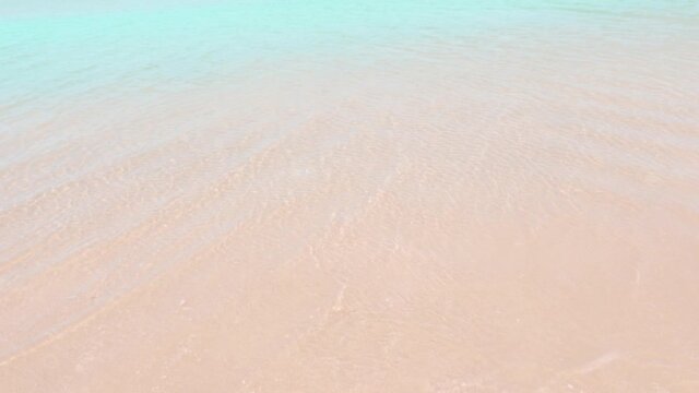 Crystal clear cyan blue sea water surface n calm ocean wave ripple crashing golden pink sandy beach in tropical summer or spring sunlight at daylight sunshine day, 4k cinemagraphs b-roll footage video