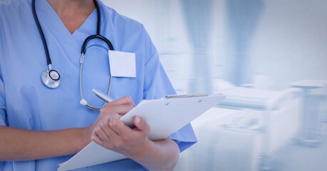 Mid section of female health worker writing on clipboard at hospital