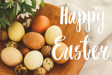 Happy Easter greeting card. Happy Easter text sign handwritten on  modern easter eggs in wooden bowl with spring flowers on rustic linen cloth. Beautiful postcard, seasons greetings © sonyachny