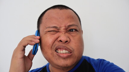 Asian man with bald hair is on the phone, with an old telephone with strange expression