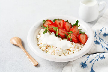 Cottage cheese, curd cheese with strawberries berries in a bowl, ogranic homemade dairy product. Healthy dairy product rich in Calcium and Protein.