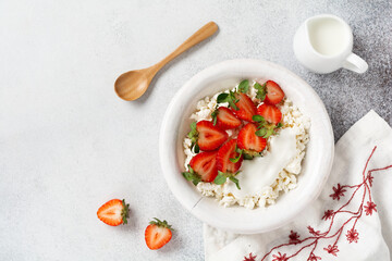 Cottage cheese, curd cheese with strawberries berries in a bowl, ogranic homemade dairy product. Healthy dairy product rich in Calcium and Protein.