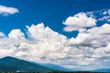 Rolling mountains with blue sky and clouds background