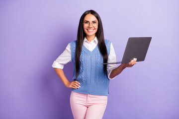 Portrait of attractive cheerful long-haired woman holding in hands using laptop isolated over violet purple pastel color background