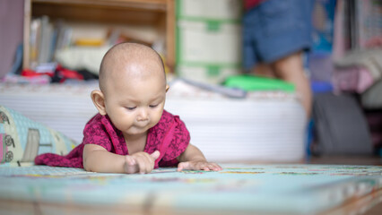 Asian Baby Girl who is 6 months old is rolling over and lifting her head up high and looking around Baby Development